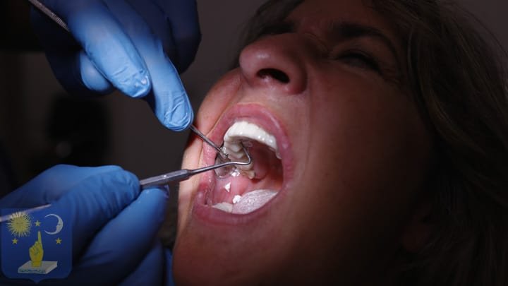 Dr Genchev cleans PFM crown on basal dental implant